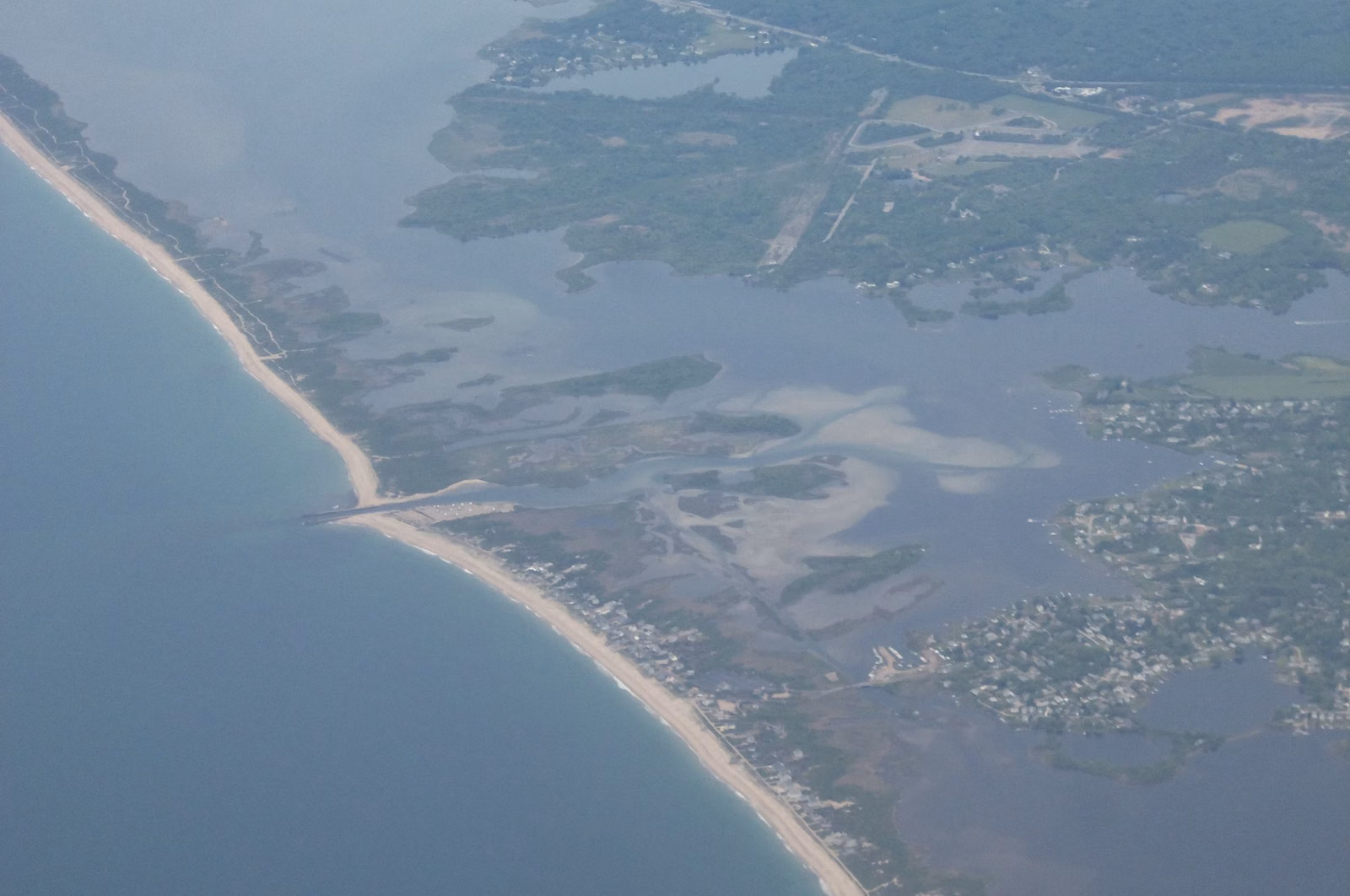 Aerial view of the Charlestown Breachway channel between the barrier beach and Ninigret Pond