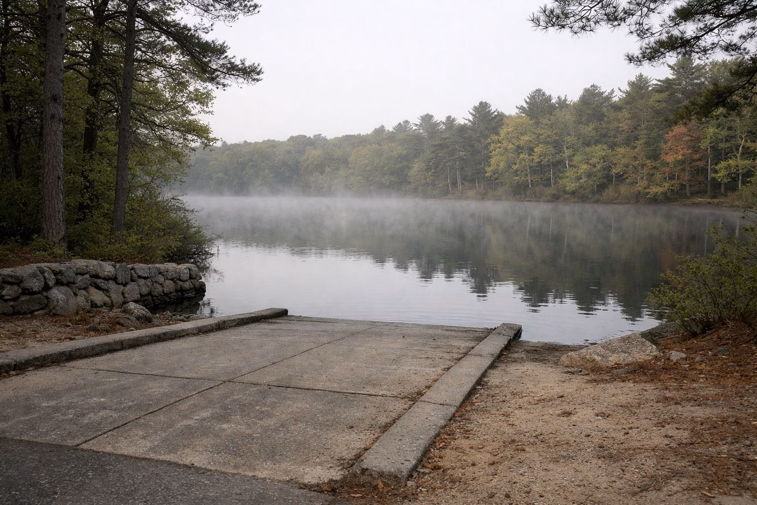 Concrete boat ramp into a calm misty pond